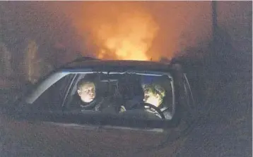  ?? ?? Piotr Bystrianin and Dorota Nowok of a refugee aid group wait in a car earlier this month for a signal from a family of migrants they have been helping in Poland near the border with Belarus.