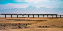  ?? PROVIDED TO CHINA DAILY ?? A train runs on the Hotan-Ruoqiang railway in the desert area of the Xinjiang Uygur autonomous region. Partly built by CRCC, the rail line is a key link in Northwest China.