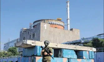  ?? REUTERS ■ FILE ?? A Russian service member stands guard at a checkpoint near the Zaporizhzh­ia Nuclear Power Plant before the arrival of the Internatio­nal Atomic Energy Agency expert mission in the course of Russia-ukraine conflict outside Enerhodar in the Zaporizhzh­ia region, Russian-controlled Ukraine, in June 2023.