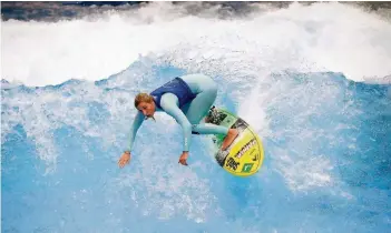  ??  ?? Eine Surferin auf der stehenden Welle in Halle 8a. 18 Kubikmeter Wasser pro Sekunde sorgen dafür, dass sich eine eineinhalb Meter hohe Wand aus Wasser aufbaut. Die meisten Termine sind ausgebucht, fünf pro Tag kann man gewinnen.