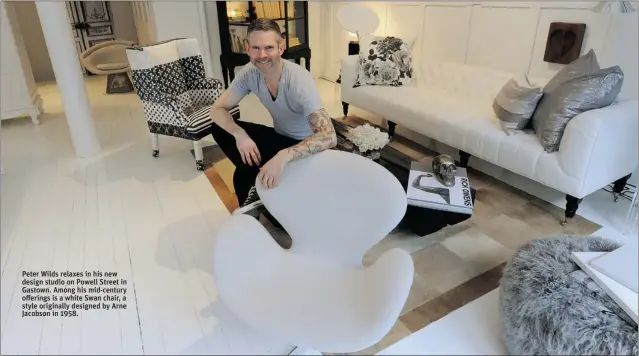  ?? MARK VAN MANEN/ PNG ?? Peter Wilds relaxes in his new design studio on Powell Street in Gastown. Among his mid- century offerings is a white Swan chair, a style originally designed by Arne Jacobson in 1958.