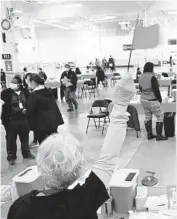  ?? STACEY WESCOTT/CHICAGO TRIBUNE ?? Nurse Barb Parness raises her flag in March to take on another person to receive the Moderna COVID-19 vaccine. Parness and others were administer­ing shots inside a former Sam’s Club in Batavia.