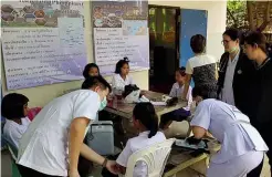  ??  ?? ABOVE: Medical staff at Ban Krang School in Thailand, where 16 schoolgirl­s fainted while being vaccinated against human papilloma virus.