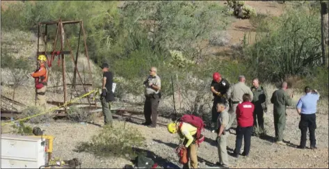  ?? VIA AP ?? This Oct. 17, photo provided by the Maricopa County Sheriff’s Office shows a rescue team gathers to a man who fell into an old abandoned mine shaft near Aguila, Ariz. MARICOPA COUNTY SHERIFF’S OFFICE rescue