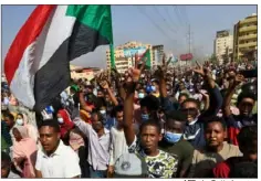  ?? AFP via Getty Images ?? Sudanese protesters lift national flags on Monday as they rally in the capital of Khartoum to denounce overnight detentions of government members by the army.