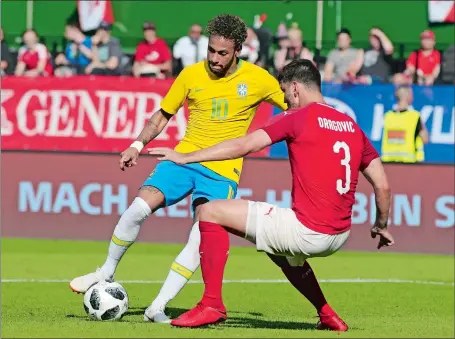  ?? RONALD ZAK/AP PHOTO ?? Brazil’s Neymar, left, duels for the ball with Austria’s Aleksandar Dragovic during a friendly on Sunday in Vienna, Austria. Neymar and Brazil will bring plenty of creative play and offensive firepower to the World Cup, which begins Thursday in Russia.