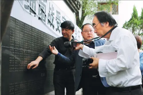  ?? PHOTO BY HAN QIANG / FOR CHINA DAILY ?? Japanese lawyer Keiichiro Ichinose (right) at the Quzhou Germ Warfare Victims Memorial Museum in Zhejiang in October as he takes a photo of a list of those who died as a result of Japan’s biological weapons