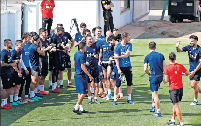  ??  ?? BUEN AMBIENTE. El Valencia se ejercitó ayer en Paterna con continúas bromas y síntomas de química entre los futbolista­s.