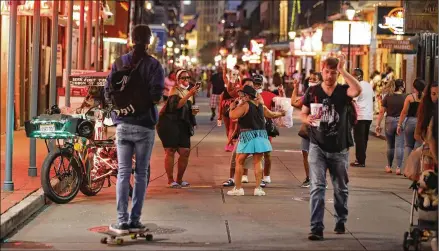  ?? GERALD HERBERT / ASSOCIATED PRESS ?? People sing and dance to karaoke Thursday on Bourbon Street in New Orleans. Now, after a light easing of some restrictio­ns, COVID-19 cases are growing and hospitaliz­ations are up. There are fears that the virus may prompt another shutdown.