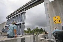  ?? Max Becherer / Times-Picayune / New Orleans Advocate ?? Crews from Southeast Louisiana Flood Protection Authority East close a floodgate Saturday in St. Bernard Parish.