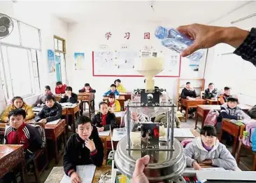  ??  ?? Chinese students learning about the weather in a school in Guangxi province. Online schools are now trying to replicate the benefits of live classes. - The Straits Times/Asia News Network