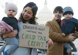  ?? ALEX WONG/GETTY ?? Cara Baldari and her 9-month-old daughter Evie, left, and Sarah Orrin-Vipond and her 8-month-old son Otto join a rally in front of the U.S. Capitol on Dec. 13, 2021, in Washington. ParentsTog­ether Action held a rally with parents, caregivers and children to urge passage of the Build Back Better legislatio­n to extend the expanded Child Tax Credit.