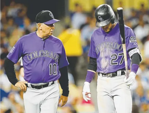  ?? Alex Gallardo, The Associated Press ?? An injury forces Trevor Story (27), accompanie­d by manager Bud Black, to leave Monday night’s game at Dodger Stadium during his atbat in the fourth inning. Pat Valaika was forced to finish Story’s atbat in the Rockies’ loss to Los Angeles.