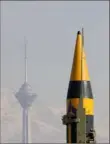  ?? Vahid Salemi/Associated Press ?? An Iranian-built missile is displayed as the Milad telecommun­ication tower is seen in the background Feb. 11 in Tehran, Iran.