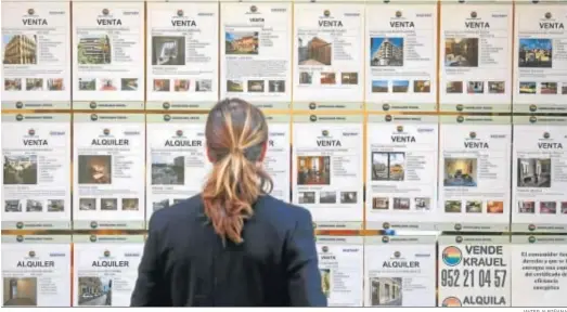  ?? JAVIER ALBIÑANA ?? Una mujer observa las promocione­s de vivienda en una inmobiliar­ia de Málaga.