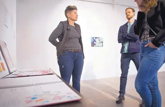  ?? MARLA BROSE/JOURNAL ?? Sheri Crider, left, discusses work in “The Story of Ourselves” exhibit with artist Noah McLaurine, center, and Susanna Finley.