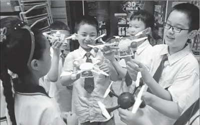  ?? CUI XIAO / FOR CHINA DAILY ?? Children from Nanjing Lasa Road Primary School show drones that were produced using 3-D printing technology at an educationa­l exchange event in Nanjing, Jiangsu province, on Wednesday. More than 60 teachers and students from Taiwan and Hong Kong are...