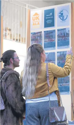  ?? Picture: Kris Miller. ?? House hunters browsing an estate agent’s window on Whitehall Crescent, Dundee.