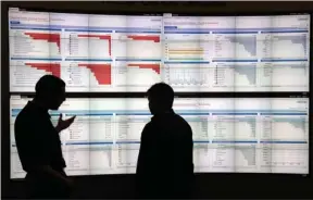  ?? The Associated Press ?? CYBERSLEUT­HS Stijn Vanveerdeg­hem, left, an engineer with Cisco, shows graphics with live wireless traffic to FedEx employee Barry Poole on April 22 during the RSA Conference in San Francisco, where threat analysts, security vendors and corporate IT...