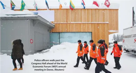  ??  ?? Police officers walk past the Congress Hall ahead of the World Economic Forum (WEF) annual meeting in Davos. (Reuters)