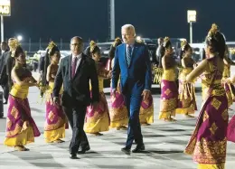  ?? DOUG MILLS/THE NEW YORK TIMES ?? Pres. Joe Biden walks past Balinese dancers after disembarki­ng Air Force One upon arrival to attend the G20 Summit at Ngurah Rai Internatio­nal Airport in Bali, Indonesia, on Sunday.