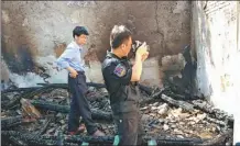  ?? ?? Fan Youhong (front) takes photos at the scene of a fire.