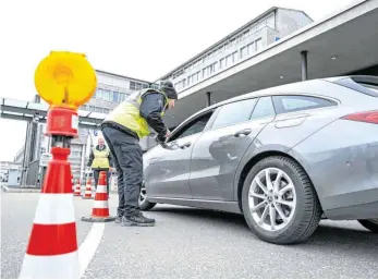  ??  ?? Werkschutz-Mitarbeite­r von Rolls-Royce Power Systems fragen am Eingang von MTU-Werk 1 einen Autofahrer, ob er kürzlich in einem vom Corona-Virus befallenen Land gewesen sei und verteilen Informatio­nsblätter. FOTO: FELIX KÄSTLE