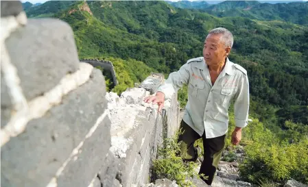  ??  ?? Local villager Zhang
Heshan the Great Wall in Qinhuangda­o, north China’s Hebei Province. He has been a voluntary ranger for 42 years. — Xinhua