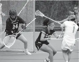  ?? KARL
MERTON FERRON | THE BALTIMORE SUN ?? Maryland attacker Brindi Griffin (1) shoots around Johns Hopkins midfielder Madison McPherson to score on goalkeeper Kathleen Garvey (24) during the first half Wednesday.