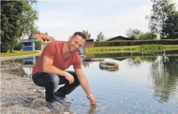  ?? FOTO: BIRGIT VAN LAAK ?? Reinhold Schmid testet frühmorgen­s schon mal die Wassertemp­eratur. Er ist seit dieser Saison der neue Pächter und Bademeiste­r des Ellmannswe­iler Freibads.