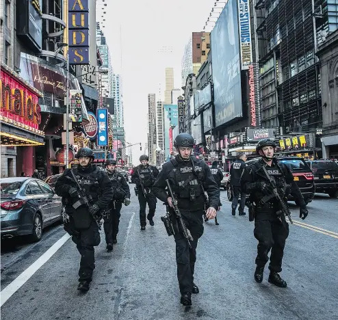  ?? JEENAH MOON / THE NEW YORK TIMES ?? An increasing­ly familiar sight: New York City police take to the streets in Manhattan following a terror attack.