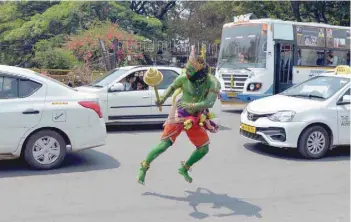  ?? — AFP ?? An artist dressed up as the deity Hanuman dances on a street to mark the Rama Navami festival in Bangalore on Sunday.