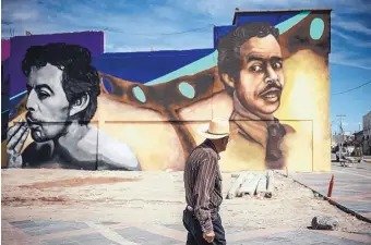  ?? ROBERTO E. ROSALES/JOURNAL ?? A man walks by a series of emerging murals by artist Elel Parra in the historic section of Ciudad Juárez featuring comedic actor known as Tin Tan, who was from the city.