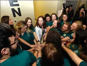  ?? NWA Democrat-Gazette/FLIP PUTTHOFF ?? Faith Paine (center), an instructor with the NWACC nursing program, leads nursing graduates Saturday in a cheer before the grads lined up for commenceme­nt.