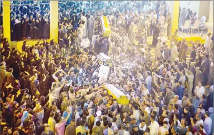  ?? (AP) ?? Coptic Christians carry coffins of their relatives who were killed during a bus attack, following their funeral service, at Abu Garnous Cathedral in Minya,
Egypt on May 26.