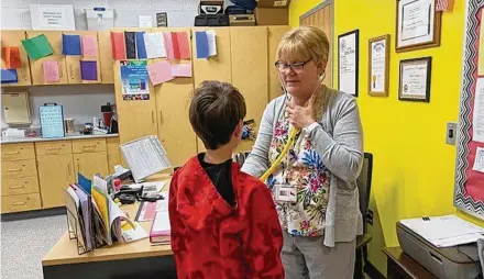  ?? CONTRIBUTE­D ?? Fairfield Schools Lead Nurse Pam Buehler, seen here tending to a sick student, is among the many local school nurses now being lauded for their hard work after the onset of the COVID-19 pandemic in 2020. State and local school officials say the nurses were heroes in keeping thousands of students and school staffers safe during the deadlier days of the now fading pandemic.