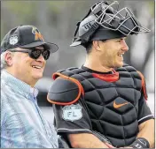  ?? RICHARD GRAULICH / THE PALM BEACH POST ?? Marlins owner Jeffrey Loria talks to catcher A.J. Ellis during the first day of spring training at Roger Dean Stadium in Jupiter on Tuesday. Ellis will replace Jeff Mathis as the backup catcher.