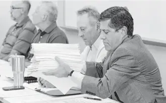  ?? Michael Wyke ?? MUD 386 attorney Howard Cohen, holding petitions presented by residents attending the group’s meeting Thursday, said nothing could have prevented the flooding from Hurricane Harvey.