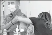  ?? Mario Tama/Getty Images/TNS ?? Jorge Usatorres (left) receives a dose of the monkeypox vaccine at a pop-up clinic at the West Hollywood Library on Wednesday.