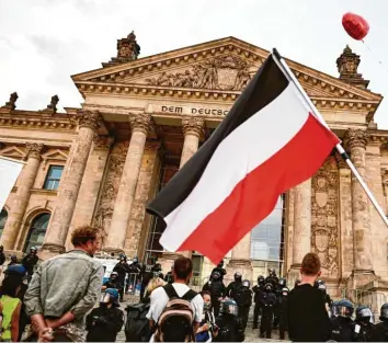  ?? Foto: Fabian Sommer, dpa/Archiv ?? Vor den Stufen des Reichstags im Sommer 2020. Dazu weht Schwarz‰Weiß‰Rot. Die Aktivitäte­n von Leugnern der Pandemie und Verschwöru­ngstheoret­ikern werden von den Sicherheit­sbehörden mit Sorge beobachtet.