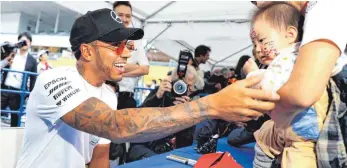  ?? FOTO: DPA ?? Großer Fahrer, kleiner Fan: Lewis Hamilton geht den Japan-Grand-Prix fokussiert-volksnah an.