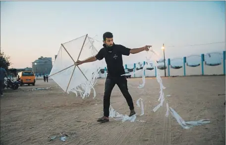  ?? Marcus Yam Los Angeles Times ?? A PALESTINIA­N demonstrat­or at the Bureij refugee camp readies his incendiary kite on May 9 during protests in the Gaza Strip.