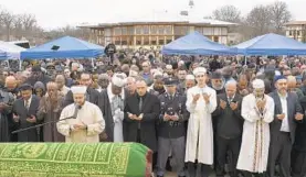  ?? MARVIN JOSEPH/AP ?? Imam Ali Tos of the Diyanet Center of America prays over the body of fallen Prince George's County Cpl. Mujahid Ramzziddin.