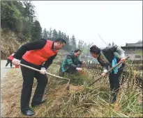  ?? ?? Left: Liang Zuying, head of the local women’s federation, removes weeds to lay the groundwork for planting trees.