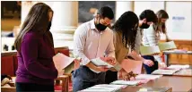  ?? HYOSUB SHIN/HYOSUB.SHIN@AJC.COM ?? Senate office staff Tuesday prepare Rules Calendars for today’s session, the final date for a bill to be passed by both chambers before being sent to the governor.