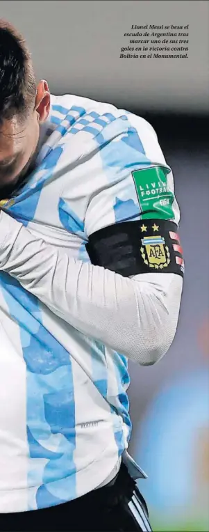  ??  ?? Lionel Messi se besa el escudo de Argentina tras marcar uno de sus tres goles en la victoria contra Bolivia en el Monumental.