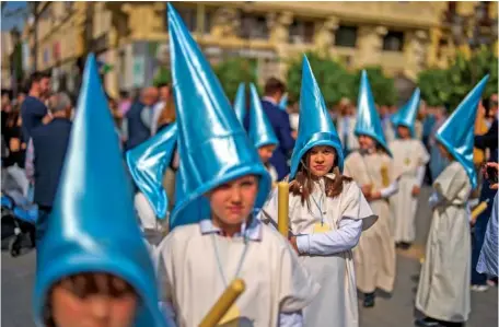  ?? AP PHOTO/ MANU FERNANDEZ ?? Above: On Friday, children wearing hoods take part in a procession ahead the Holy Week at Tendillas square in Cordoba, Spain. Hundreds of procession­s will take place throughout Spain during the Easter Holy Week.