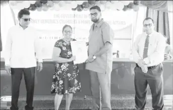  ?? ?? President Irfaan Ali (second from right hands over a land title to a resident as the Attorney General and Minister of Legal Affairs Anil Nandlall, SC (left) and another official look on (DPI photo)