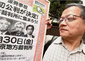  ?? — AFP ?? In the dock: A man holding a board showing the first trial of three former executives of Tepco in front of the Tokyo District Court.