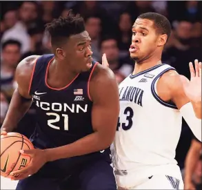  ?? Tim Nwachukwu / Getty Images ?? UConn’s Adama Sanogo, left, looks to pass against Villanova’s Eric Dixon in the second half Friday.